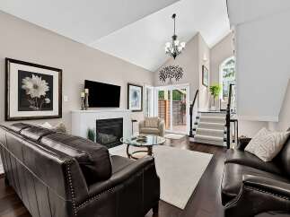 Experience luxurious living in this stunning living room featuring a vaulted ceiling and a modern fireplace.