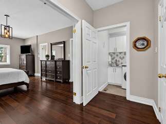 Experience comfort and convenience in this spacious bedroom featuring a plush bed and elegant dark wood furniture.