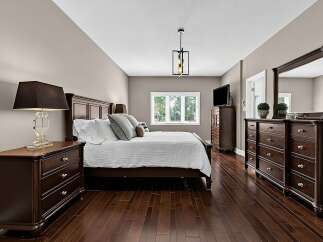 Experience luxury and comfort in this master bedroom, featuring a king-size bed with plush pillows and a crisp white duvet.