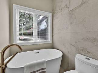 Experience modern luxury in this stunning bathroom, featuring a freestanding soaking tub perfect for unwinding.
