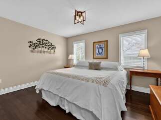 This inviting bedroom features a spacious king-sized bed adorned with elegant white linens and a decorative accent pillow.