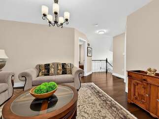Step into this inviting living space featuring a plush sofa adorned with decorative pillows, complemented by a stylish coffee table.