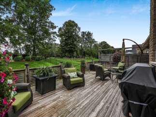 Enjoy outdoor living on this spacious wooden deck, perfect for entertaining or relaxing.