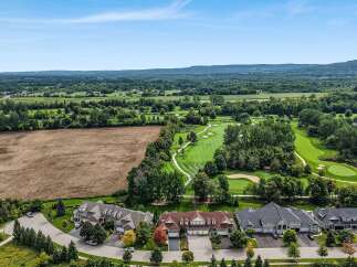 Experience luxury living adjacent to a pristine golf course with this stunning aerial view.
