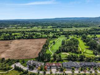 Experience luxury living adjacent to a pristine golf course with this stunning aerial view.