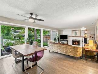 Experience seamless indoor-outdoor living with expansive windows overlooking a lush backyard, perfect for entertaining or quiet relaxation.