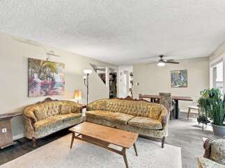 Step into this inviting living space featuring a charming floral-patterned sofa and loveseat, perfect for cozy gatherings.