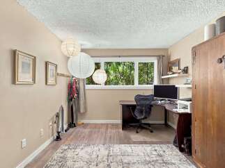 This home office features a spacious corner desk with a computer and printer, perfect for productivity.