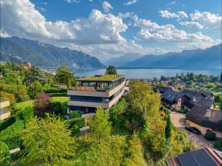 Experience luxurious living in this modern architectural gem, boasting a stunning green roof and panoramic views of the serene lake and majestic mountains.
