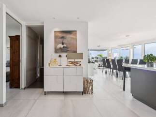 Experience modern living in this spacious open-concept home, featuring a sleek white buffet and contemporary artwork.