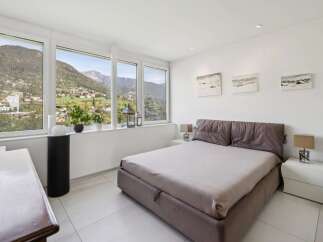Experience breathtaking mountain views from this serene bedroom, featuring expansive windows that flood the space with natural light.