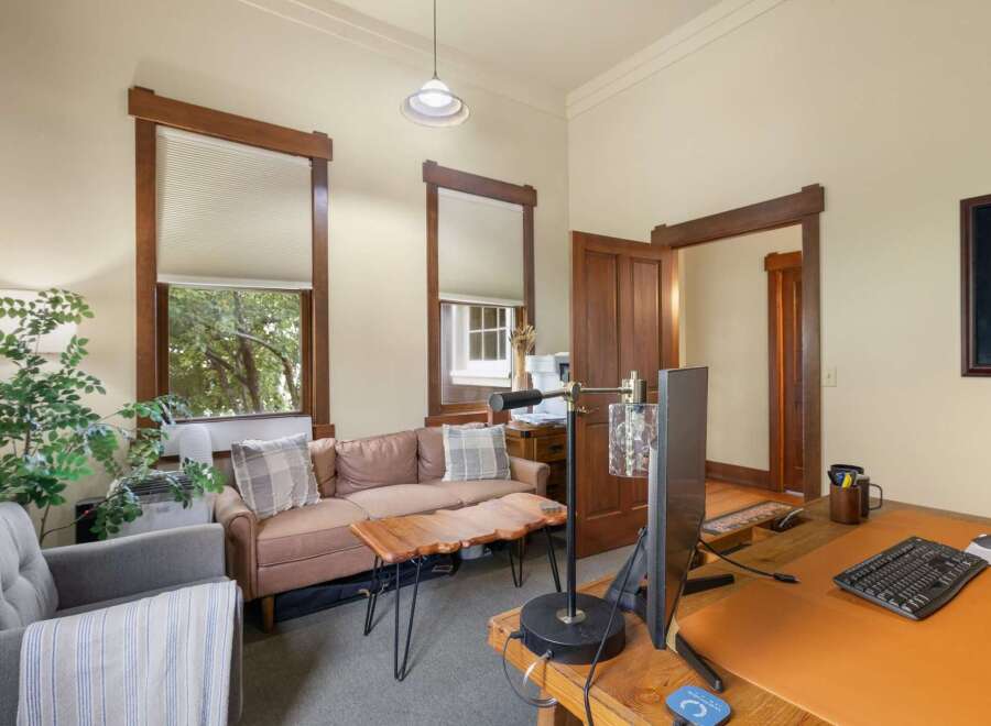 This inviting office space features a comfortable seating area with a plush sofa and armchair, perfect for client meetings or breaks.