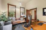 This inviting office space features a comfortable seating area with a plush sofa and armchair, perfect for client meetings or breaks.