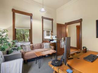 This inviting office space features a comfortable seating area with a plush sofa and armchair, perfect for client meetings or breaks.