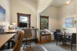 This versatile room features a dedicated workspace with a standing desk and office chair, perfect for remote work or study.