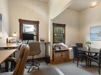 This versatile room features a dedicated workspace with a standing desk and office chair, perfect for remote work or study.