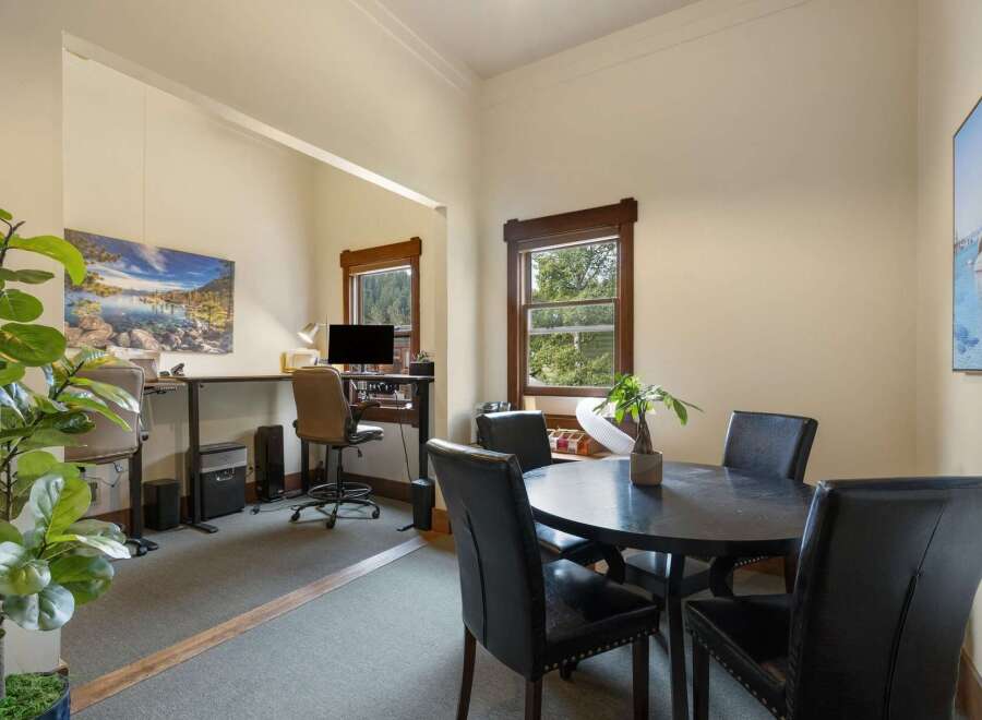 This versatile space offers a dedicated home office area with a standing desk and computer setup, perfect for remote work.