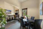 This versatile space offers a dedicated home office area with a standing desk and computer setup, perfect for remote work.