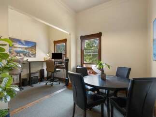 This versatile space offers a dedicated home office area with a standing desk and computer setup, perfect for remote work.
