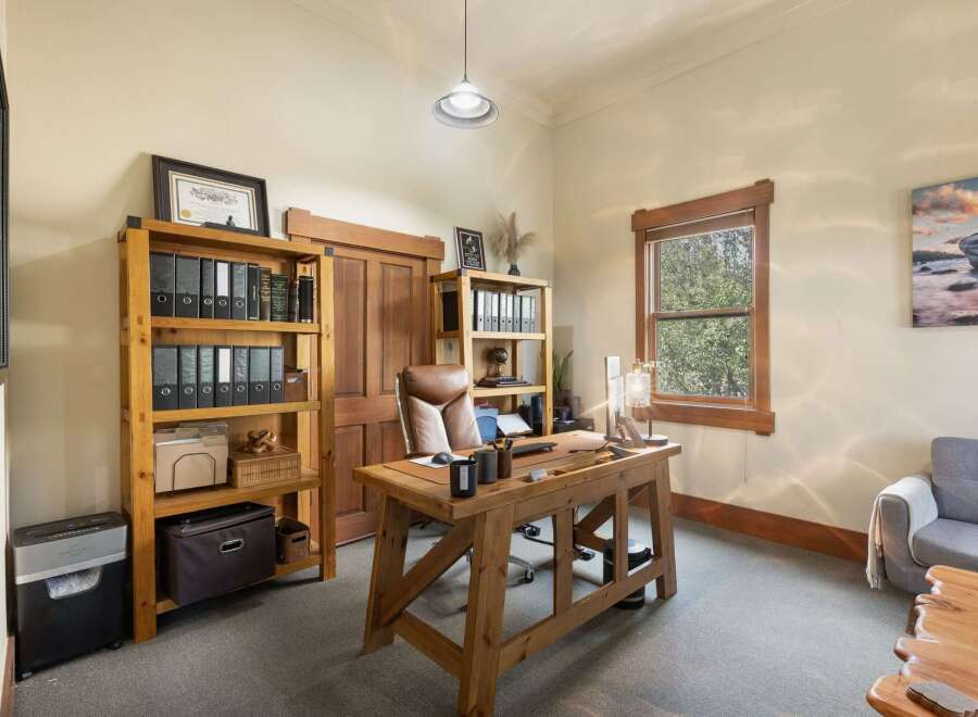 This home office features a large wooden desk with a leather desk mat, perfect for productivity.