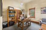 This home office features a large wooden desk with a leather desk mat, perfect for productivity.