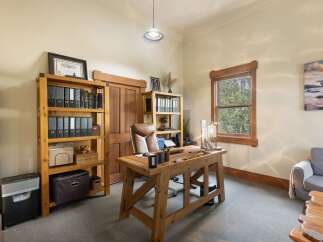 This home office features a large wooden desk with a leather desk mat, perfect for productivity.