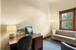 This inviting office space features a rich wooden desk with a classic lamp and two abstract art pieces, perfect for inspiring creativity.