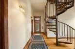 Step into this charming hallway featuring a stunning spiral staircase, perfect for adding a touch of elegance and maximizing space.