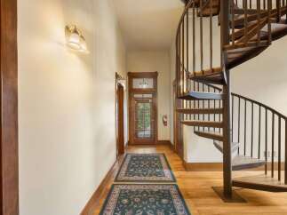 Step into this charming hallway featuring a stunning spiral staircase, perfect for adding a touch of elegance and maximizing space.