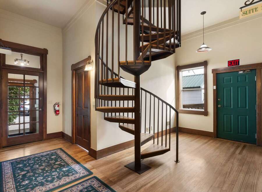 Discover unique charm in this inviting entryway featuring a striking spiral staircase as the centerpiece.