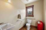 This accessible bathroom features a white toilet with grab bars for added safety and convenience.