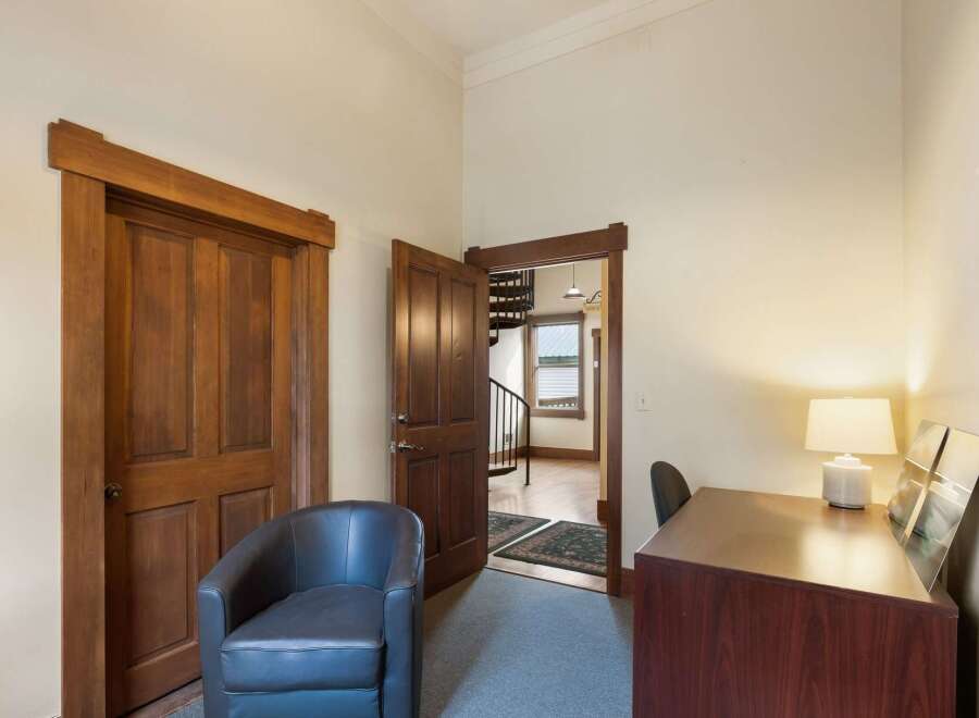 Step into this charming space featuring a comfortable armchair and a functional desk area, perfect for a home office or reading nook.