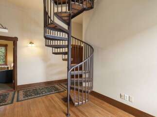 Ascend to new heights in this charming home featuring a stunning spiral staircase.