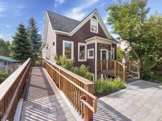 Discover the charm of Old Tonini House, a beautifully maintained property featuring a welcoming wooden ramp and accessible entrance.