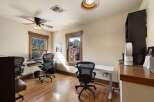 This home office features two workstations, each equipped with a comfortable ergonomic chair and a laptop.