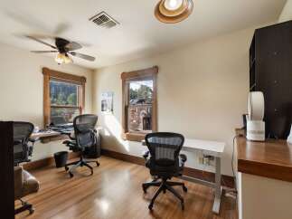 This home office features two workstations, each equipped with a comfortable ergonomic chair and a laptop.