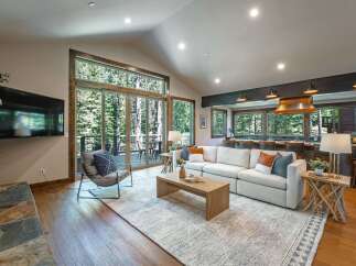 Experience luxurious mountain living in this stunning open-concept great room, featuring a soaring vaulted ceiling and expansive windows that flood the space with natural light.