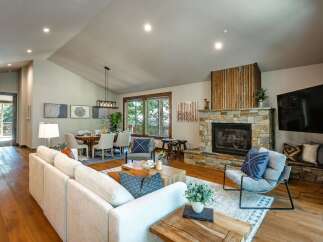 Experience modern mountain living in this stunning open-concept great room, featuring a soaring vaulted ceiling and a magnificent stone fireplace as the centerpiece.