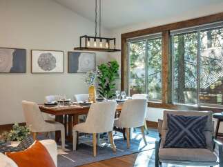 Experience elegant dining in this beautifully appointed space, featuring a rustic wooden dining table surrounded by comfortable upholstered chairs.