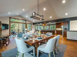 Experience modern mountain living in this stunning open-concept home, featuring a spacious dining area perfect for gatherings and a gourmet kitchen with rich wood cabinetry.