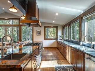 Experience luxury mountain living in this stunning kitchen, featuring a large island with a granite countertop and a professional-grade gas range.
