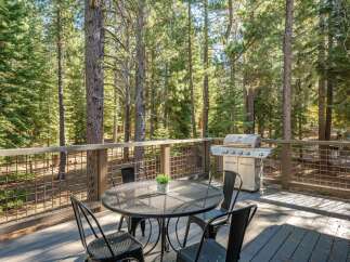 Enjoy outdoor living on this spacious deck, perfect for entertaining or relaxing amidst the serene forest.