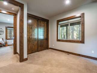 Step into this inviting bedroom featuring rustic wooden doors and trim, creating a warm and cozy atmosphere.