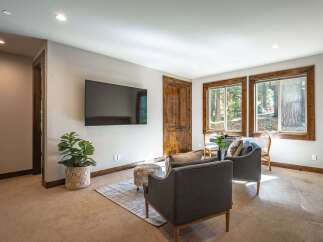 This inviting living space features a large flat-screen TV mounted on a neutral wall, perfect for entertainment.