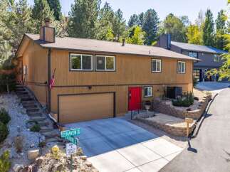 Discover this charming home featuring a warm brown exterior and a striking red front door, offering immediate curb appeal.