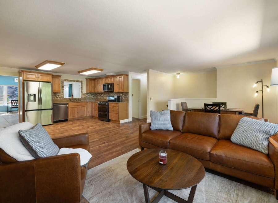 This spacious open-concept living area seamlessly blends a modern kitchen with a comfortable living room.