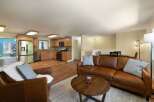 This spacious open-concept living area seamlessly blends a modern kitchen with a comfortable living room.