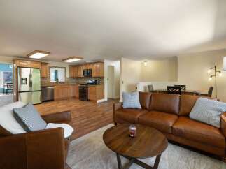 This spacious open-concept living area seamlessly blends a modern kitchen with a comfortable living room.