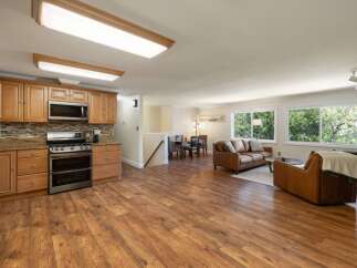 Discover this charming open-concept living space, featuring a modern kitchen with ample cabinetry and granite countertops, seamlessly flowing into a cozy living area.