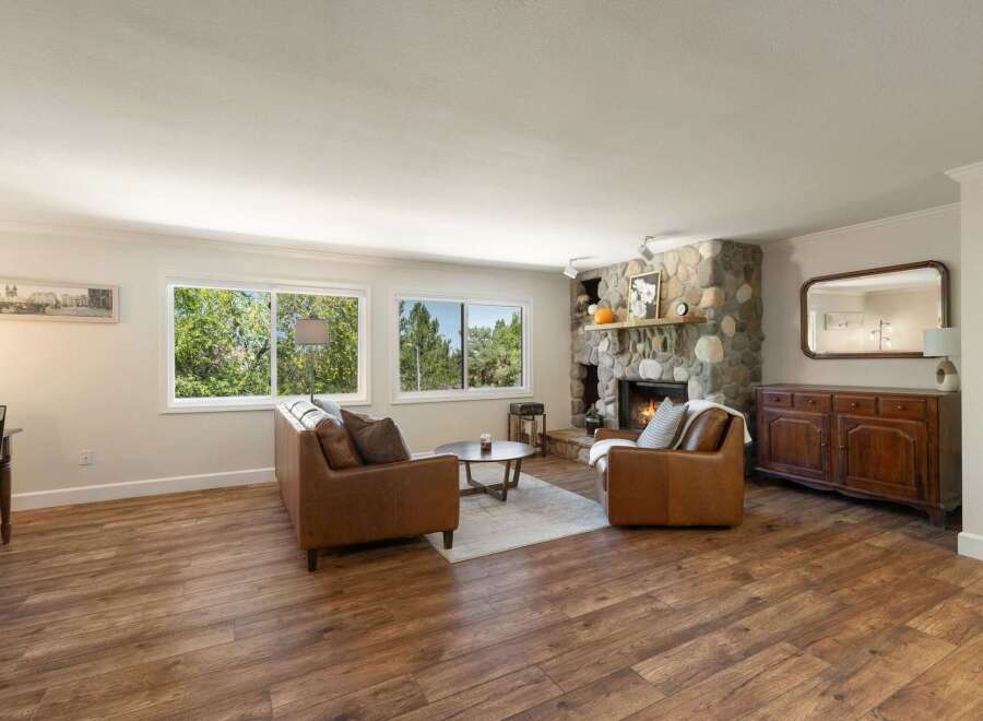 Experience cozy living in this inviting living room, featuring a stunning stone fireplace perfect for chilly evenings.